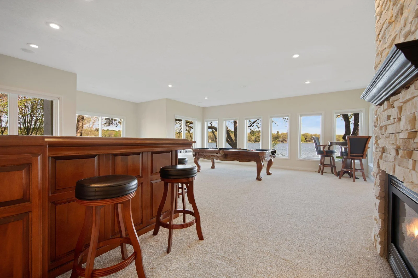 For additional entertaining, this main level bonus room boasting custom wet bar and flooded with natural light is the perfect space to gather after coming in from a day on the lake.