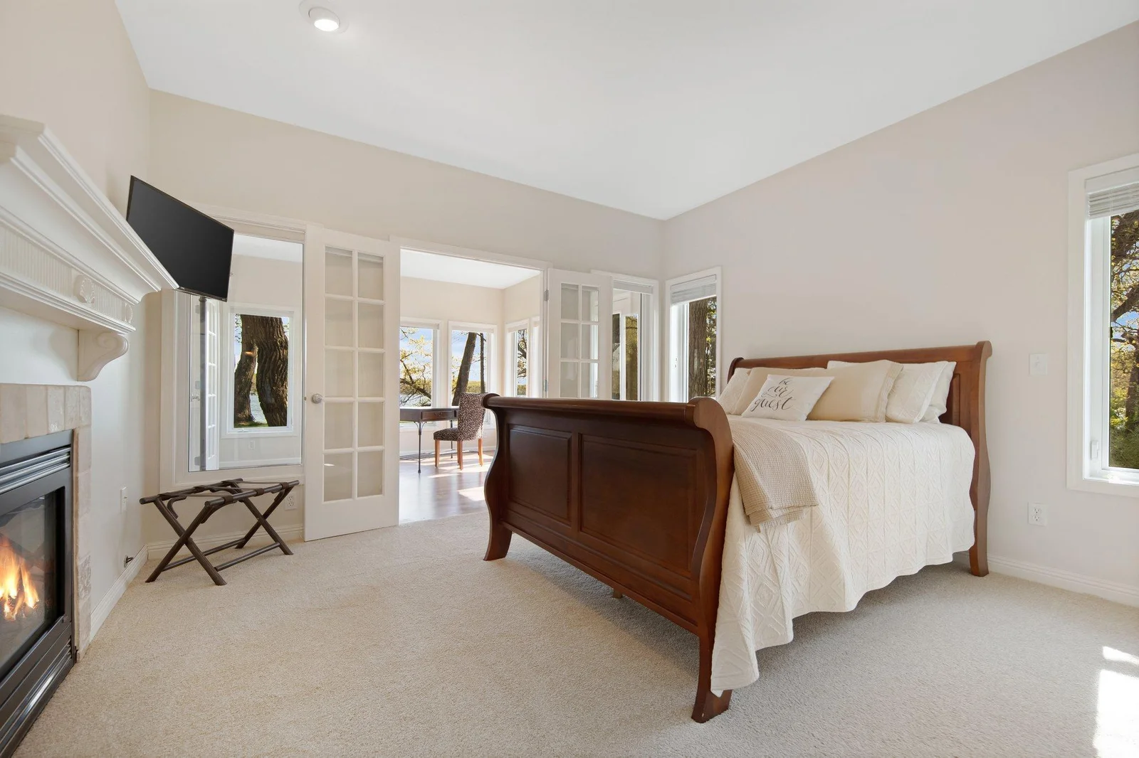 Main floor primary suite off the sunroom featuring 2 sided fireplace and on-suite bathroom.