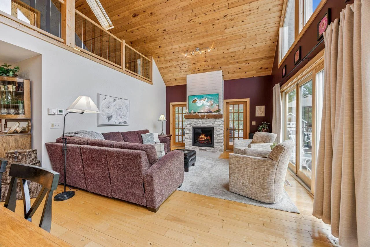 View from stairway looking into living room with doors to screened porch.
