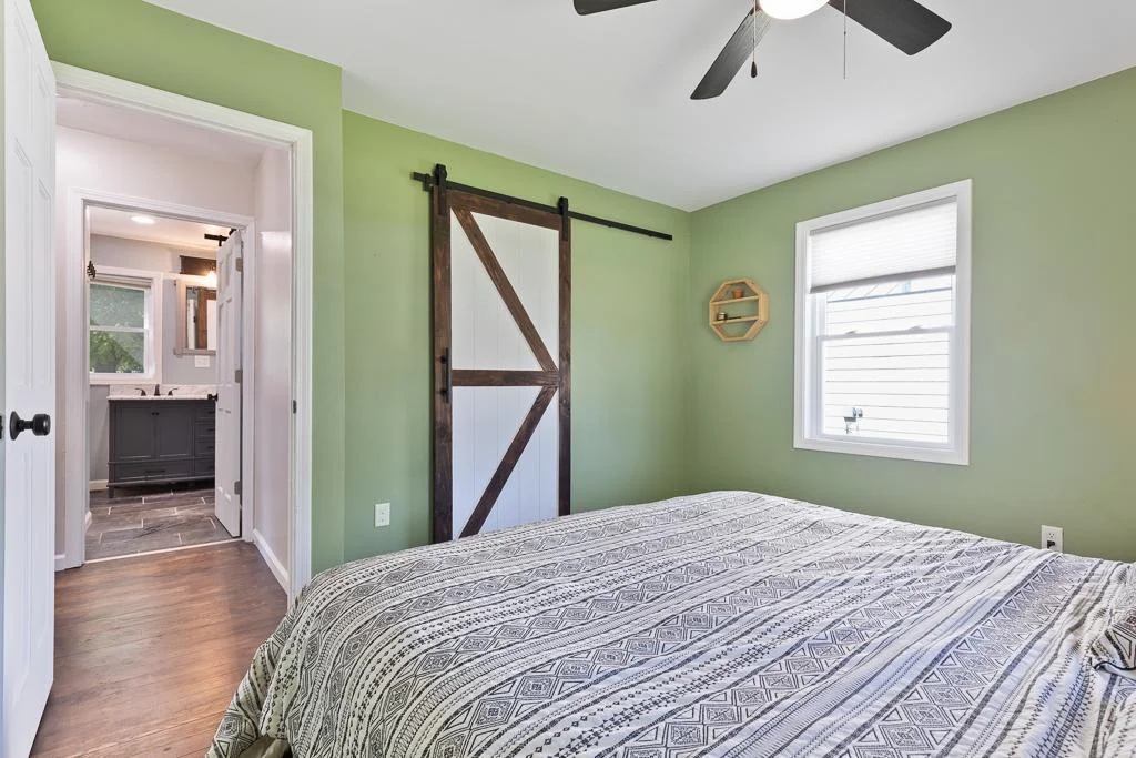 The sliding barn door to the walk-in closet is a fun feature for the room
