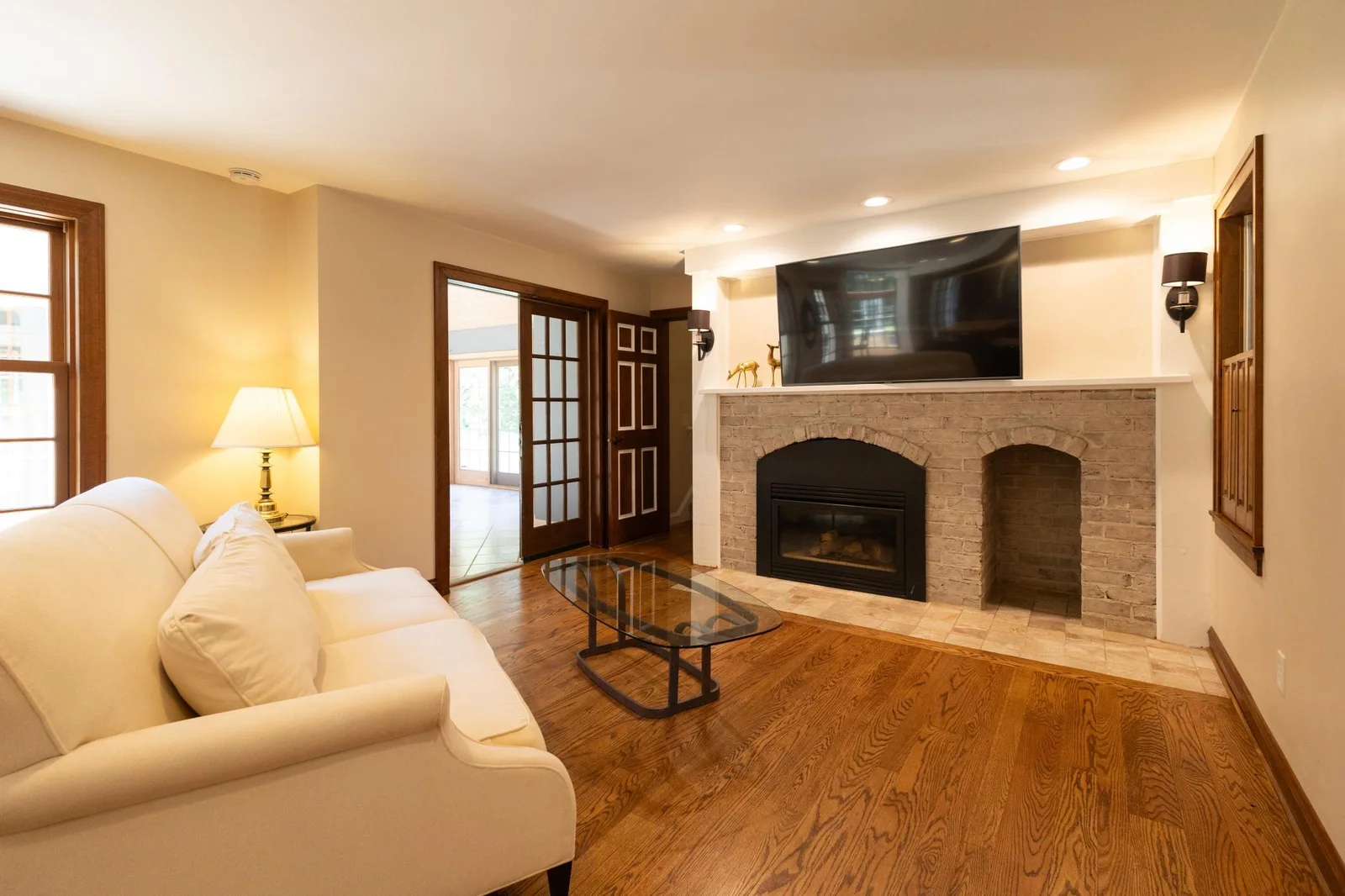The living room has beautiful hardwood floors and one of the three fireplaces in the home.