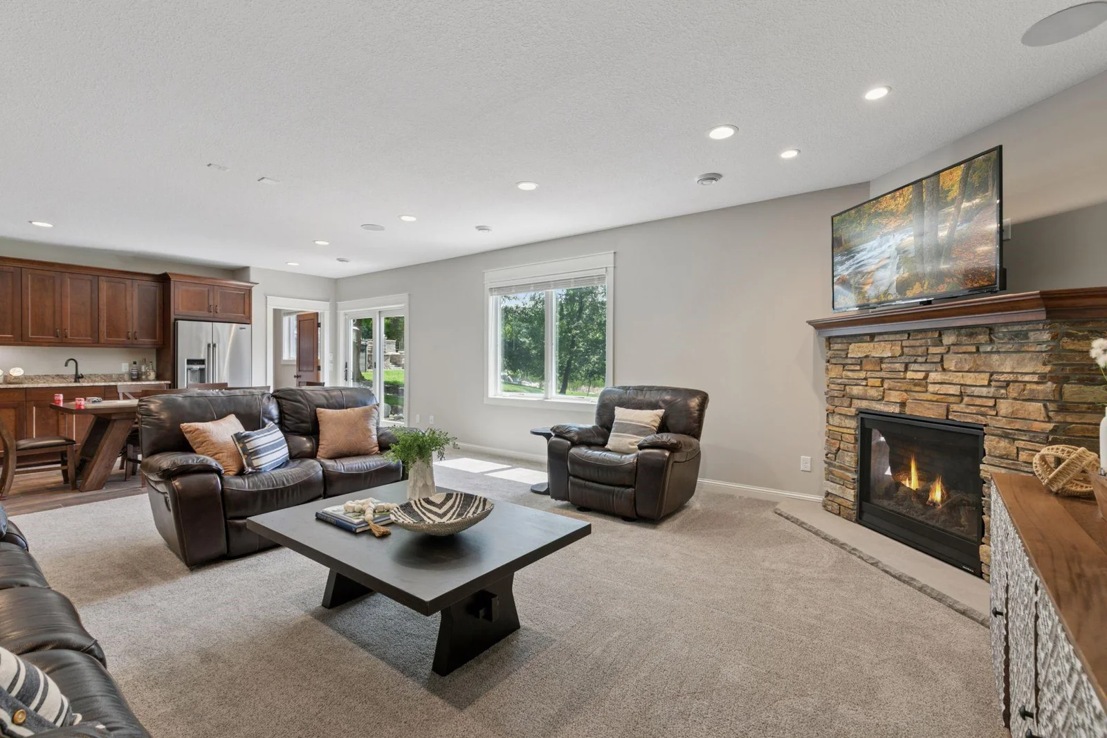 Family Room with stacked stone surround gas fireplace in the walk-out lower level.