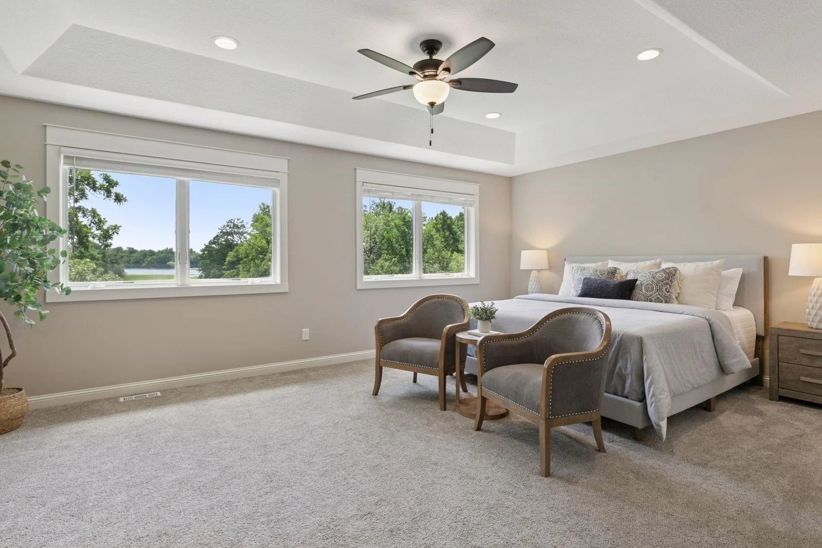 Impressive Primary Suite with tray vault ceiling accented with recessed lighting and ceiling fan.
